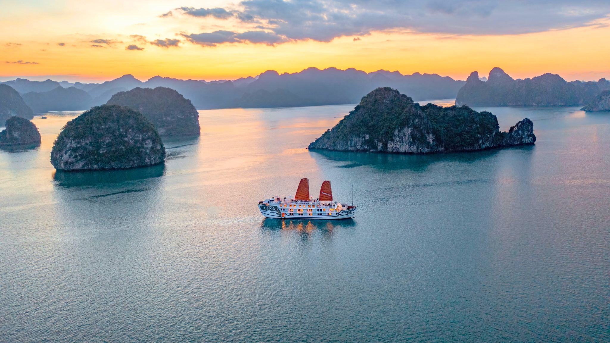 The charming junk boat slowly navigates to the most famous spots of Halong Bay