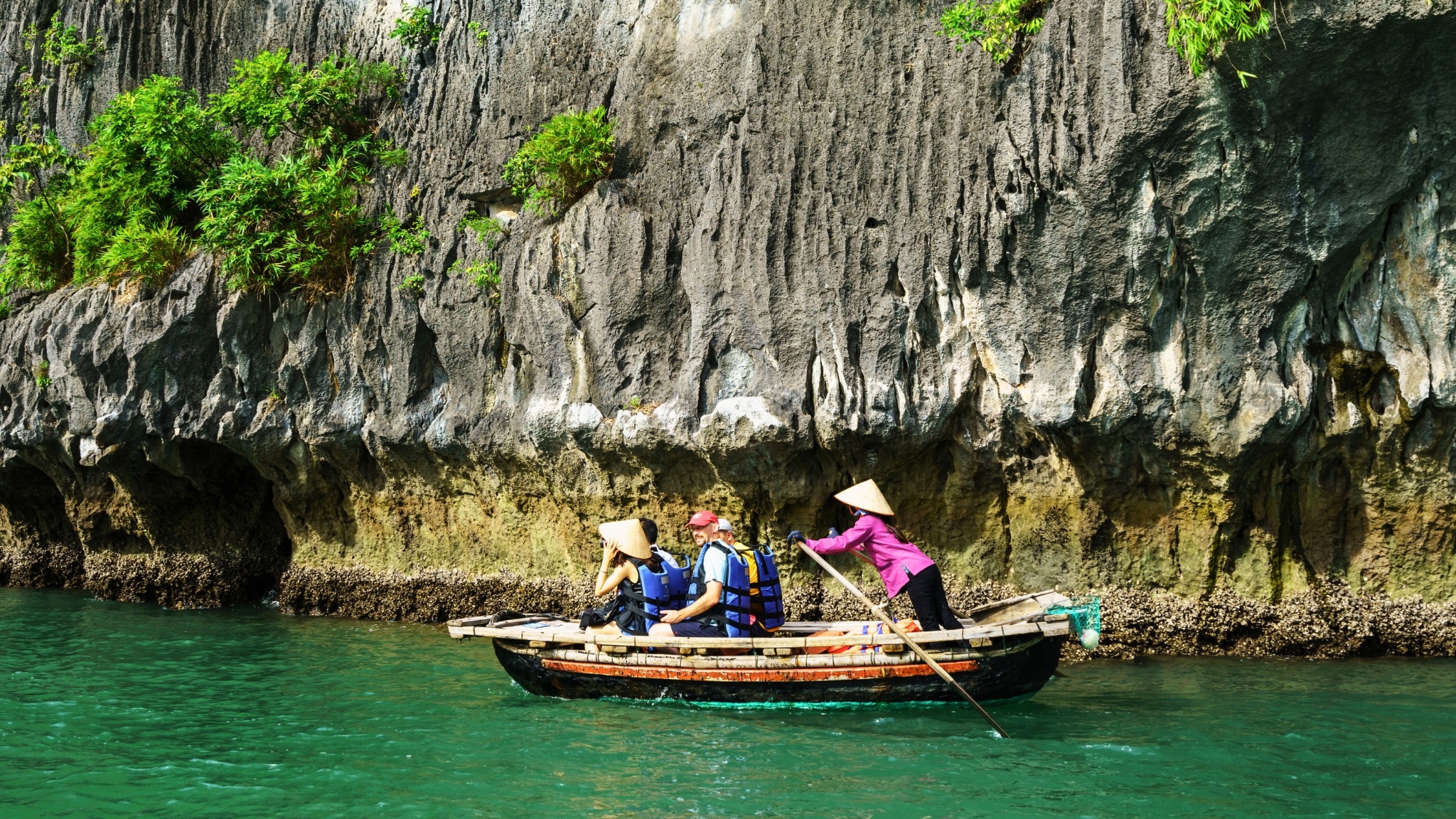 The fullest way to admire Dark & Bright Cave is leisurely sitting on a bamboo boat.