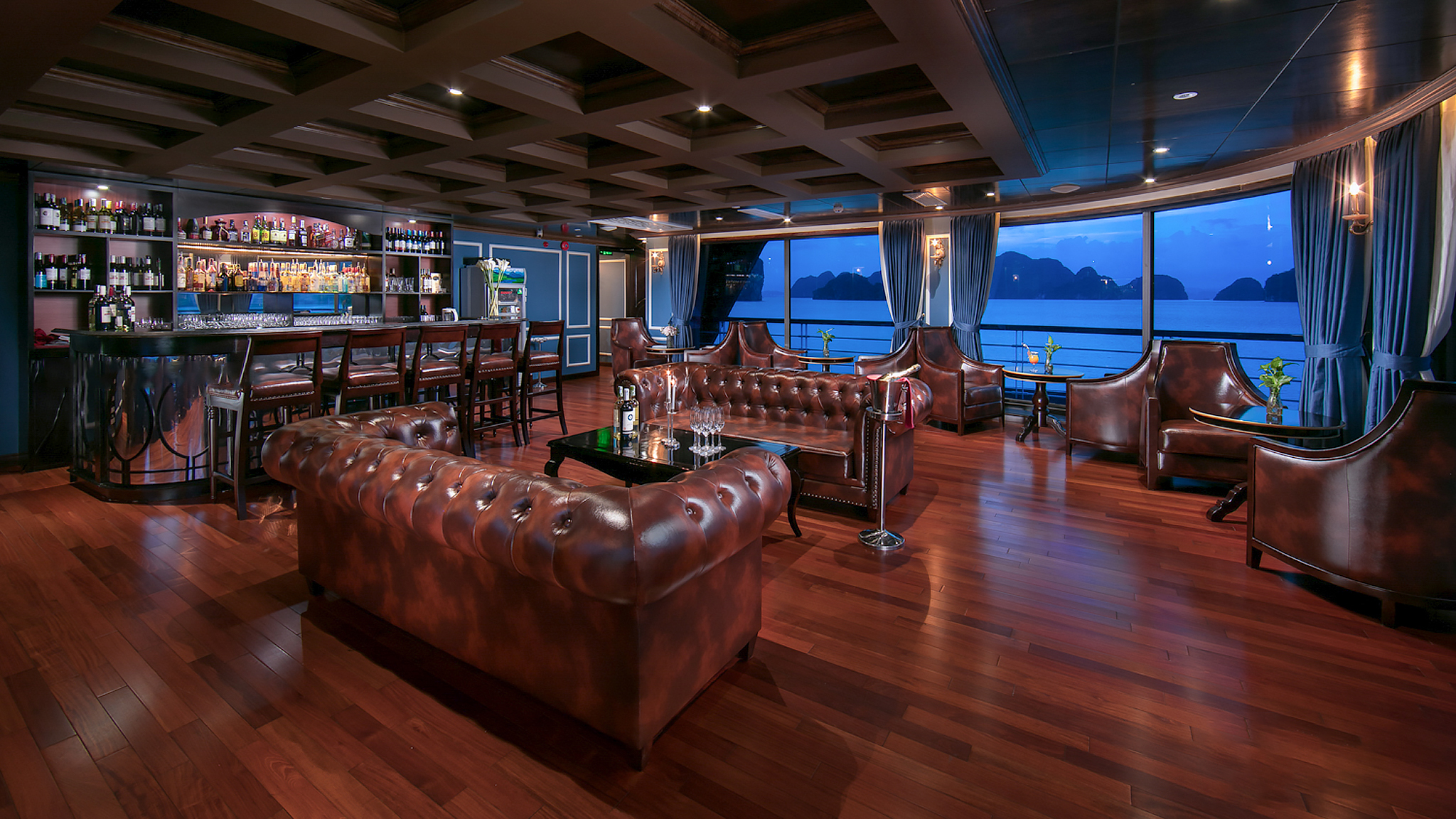 The indoor lounge features luxurious leather seats and walls of windows.