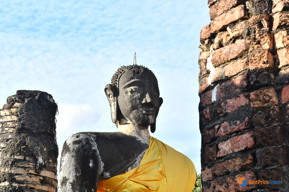 The ruined Buddha with missing eye and scarred right cheek