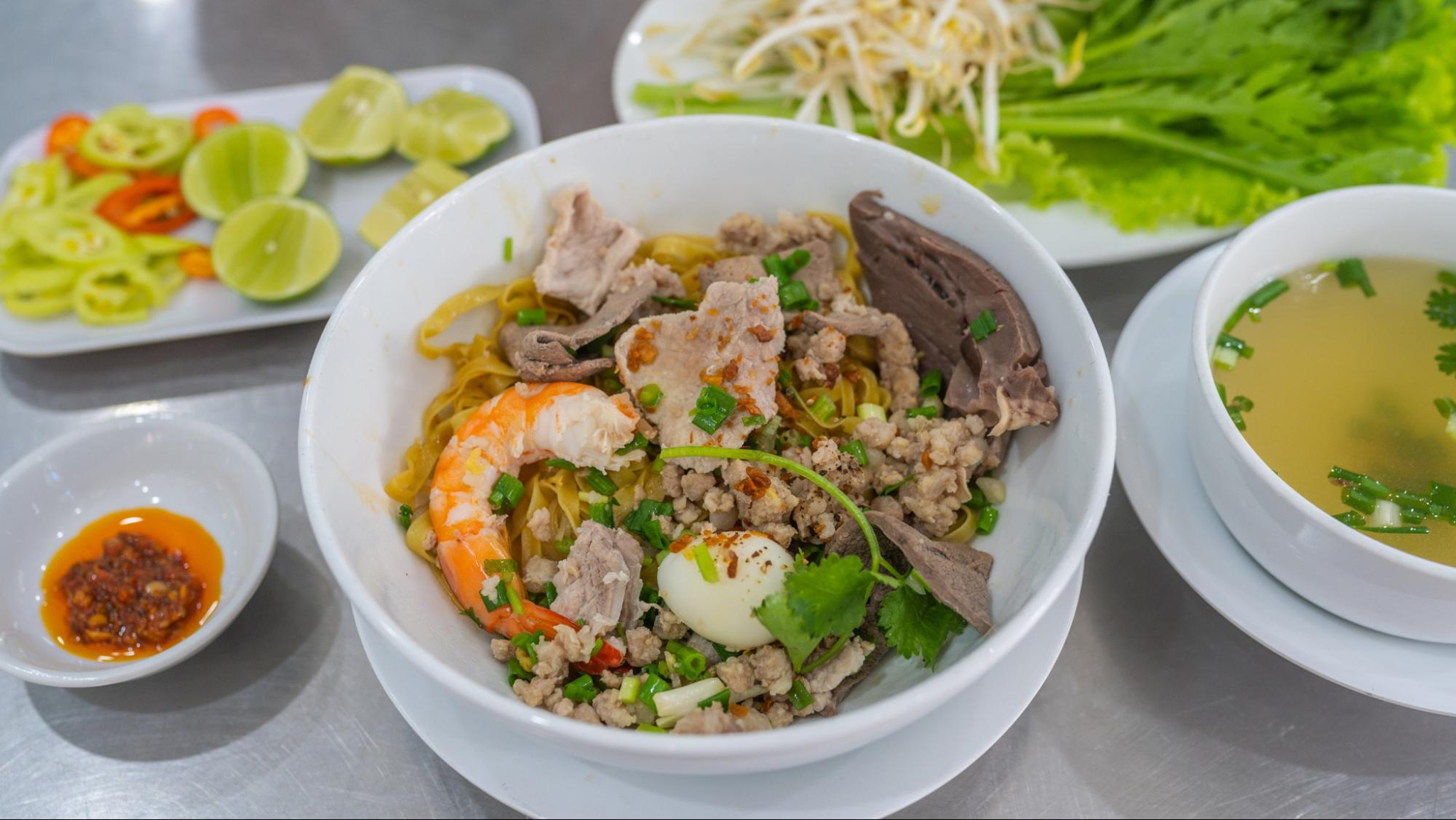 A bowl of Hu Tieu My Tho with noodles and fresh toppings