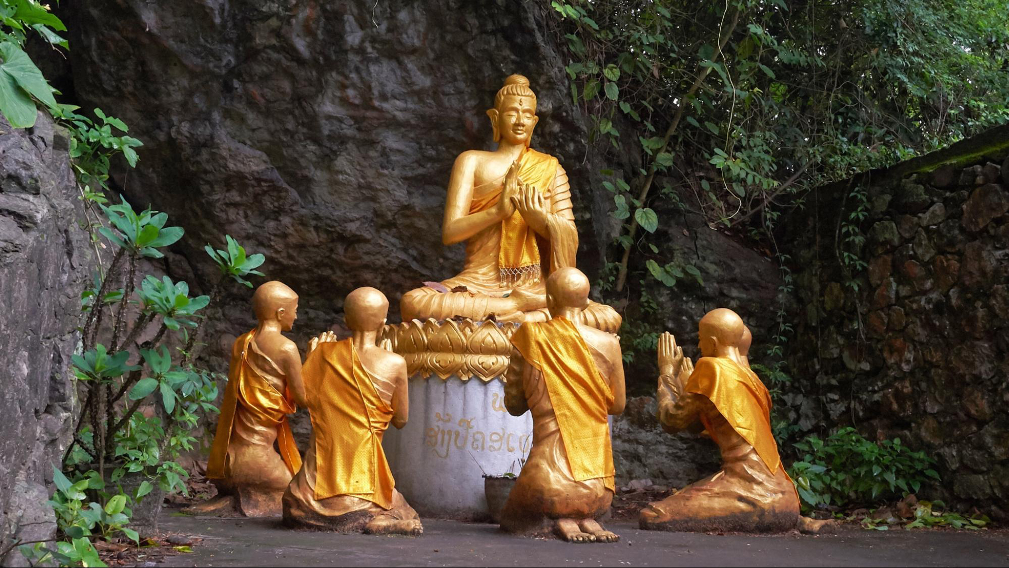 Pass by the stunning Buddha and novice monks statues on Mount Phousi