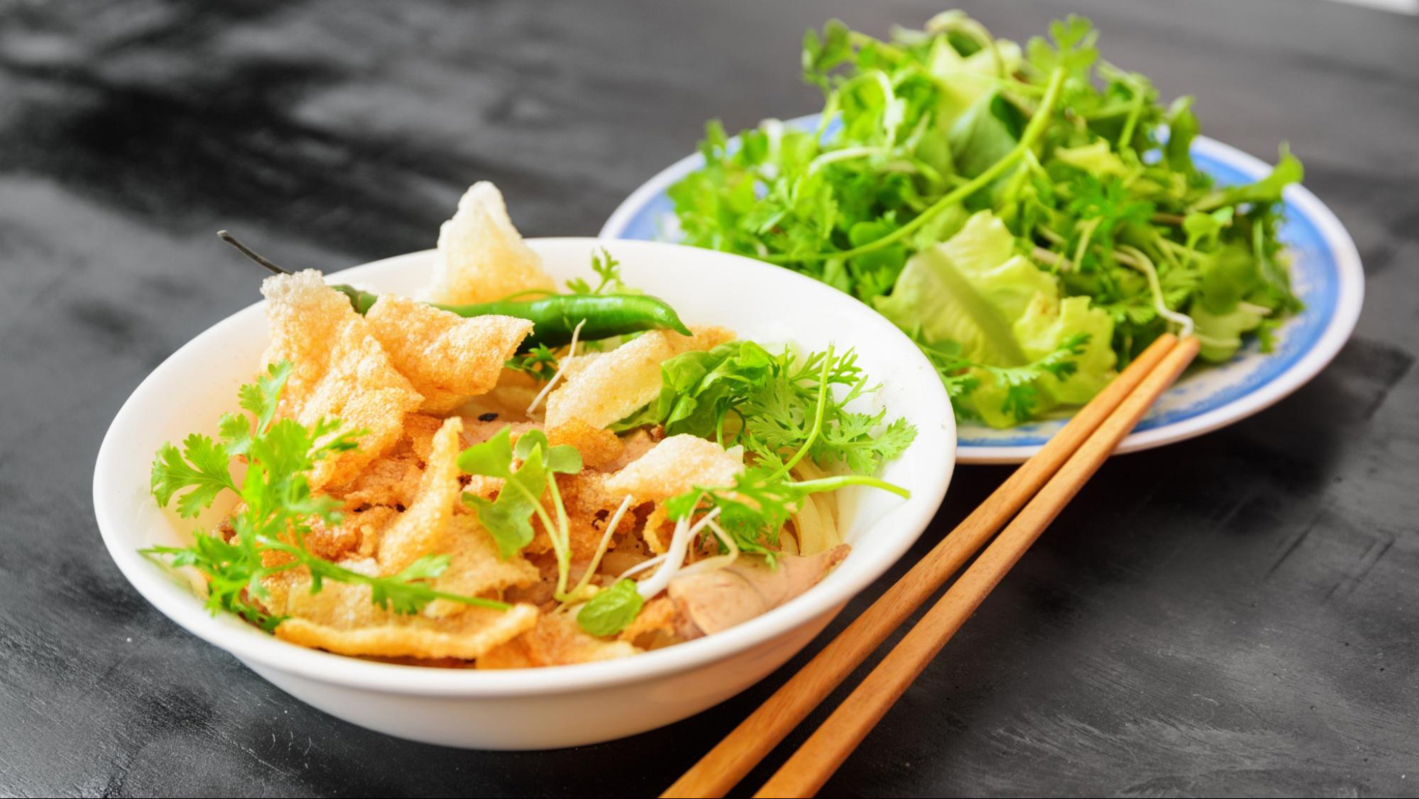 Cao Lau offers a rich blend of chewy noodles, tender pork, and fresh herbs
