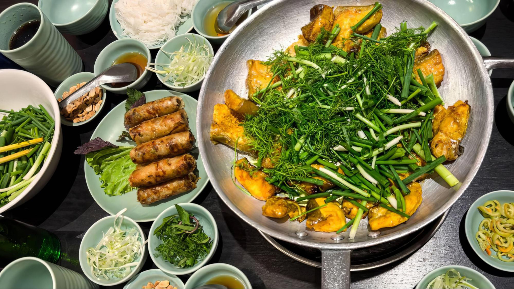 Cha Ca La Vong bursts with flavorful turmeric fish, fresh dill, and peanuts
