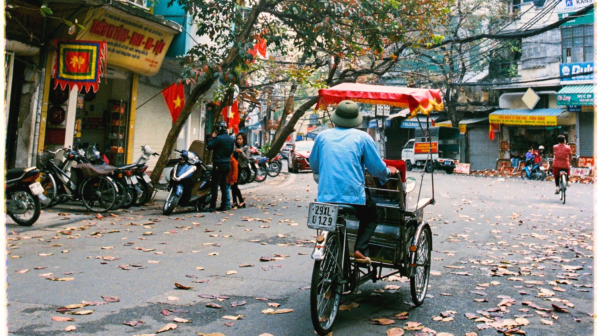 Tourists explore various shops and street life in Hanoi Old Quarter's vibrant cultural setting