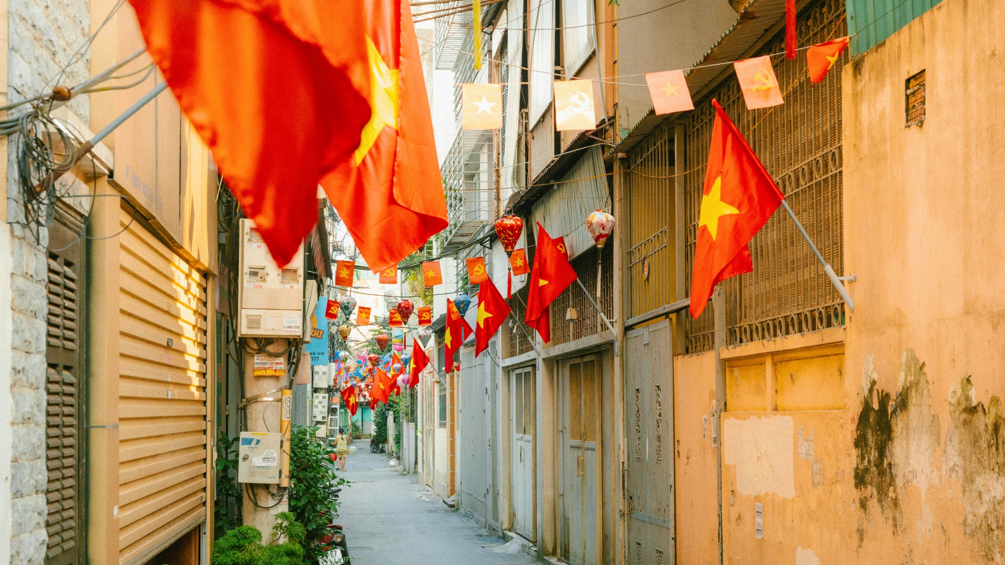 Vietnamese flags line a Hanoi street, celebrating Independence Day with bright red and yellow colors