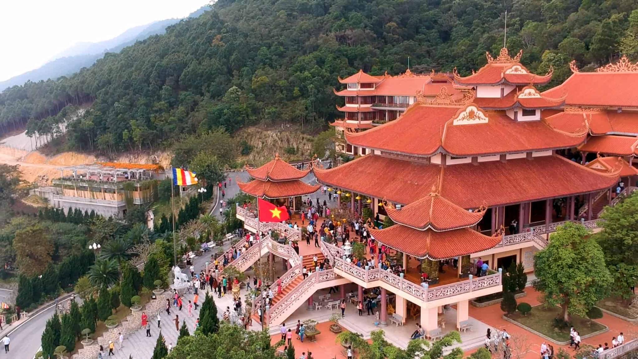 Cai Bau Pagoda overlooking the tranquil waters of Bai Tu Long Bay with traditional architecture and mountain scenery