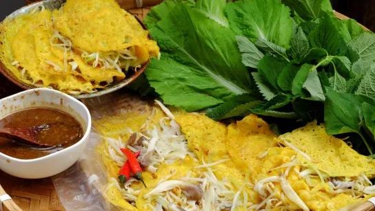 Taste Vietnamese Sizzling Crepes With Crispy Batter, Fresh Herbs, And Savory Fillings