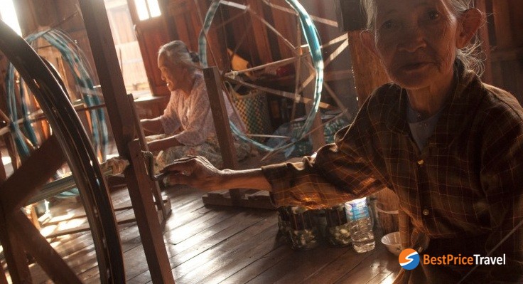 Weavers at work on a wooden loom