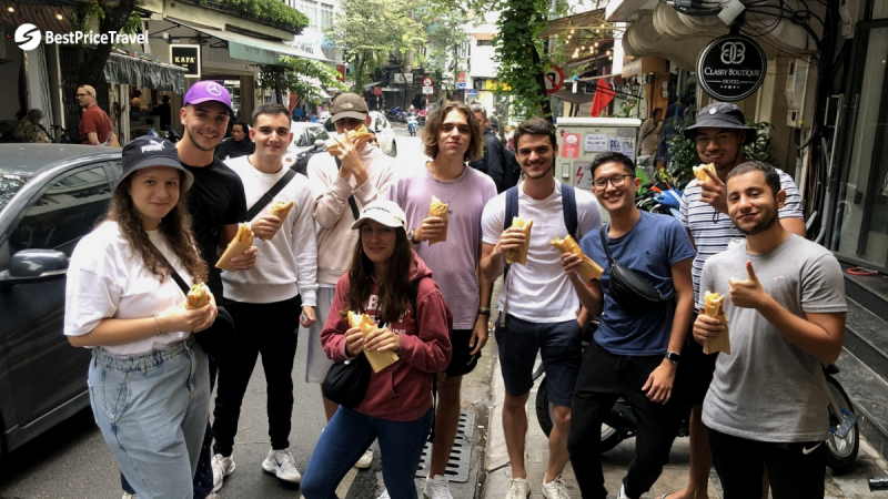 A Group Of Young Travelers Enjoy Vietnamese Bread Banh Mi