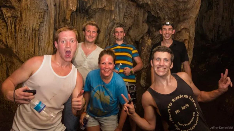 Tourists Exploring The Cave By A Large Group
